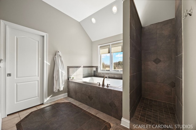 bathroom with vaulted ceiling, a tile shower, tile patterned flooring, a bath, and baseboards