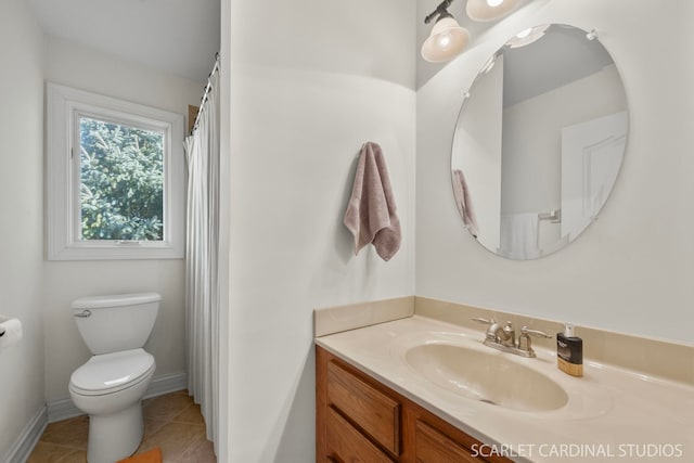 bathroom with baseboards, toilet, tile patterned flooring, and vanity