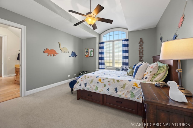 bedroom with vaulted ceiling, light colored carpet, baseboards, ceiling fan, and ensuite bathroom