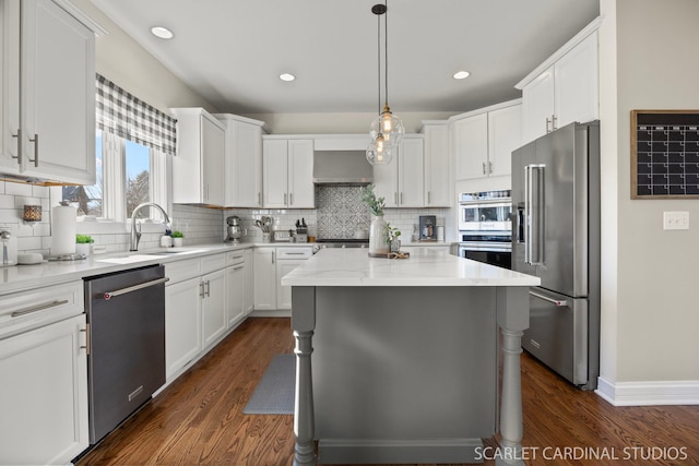 kitchen featuring a center island, a sink, white cabinets, and appliances with stainless steel finishes
