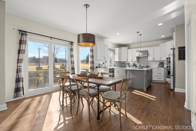 dining space with dark wood finished floors, baseboards, and recessed lighting