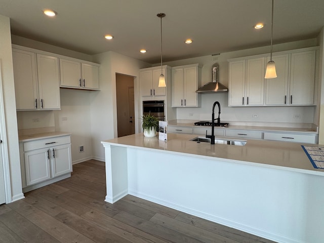 627 Henry Ln, Oswego, IL 60543 - kitchen with wall chimney exhaust hood, white cabinets, dark wood-style flooring, decorative light fixtures, and recessed lighting