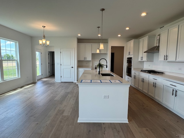 627 Henry Ln, Oswego, IL 60543 - kitchen featuring stainless steel gas cooktop, a chandelier, white cabinets, an island with sink, and recessed lighting