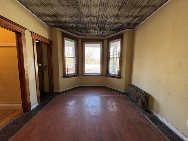 8216 S Brandon Ave, Chicago, IL 60617 - unfurnished room featuring dark wood-style floors, radiator heating unit, wood ceiling, and baseboards