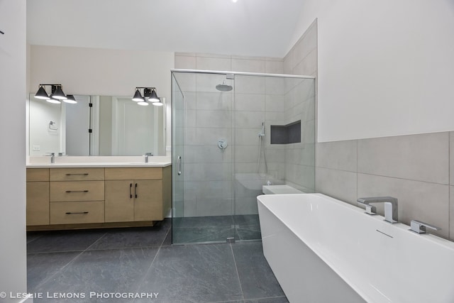 bathroom featuring tile walls, vanity, a shower stall, and a freestanding bath