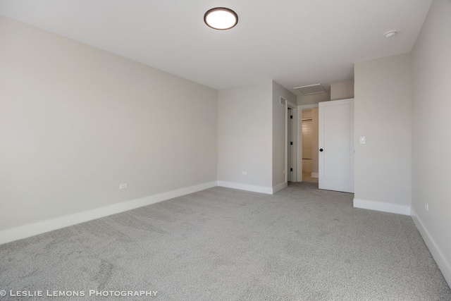 unfurnished room with visible vents, light carpet, and baseboards