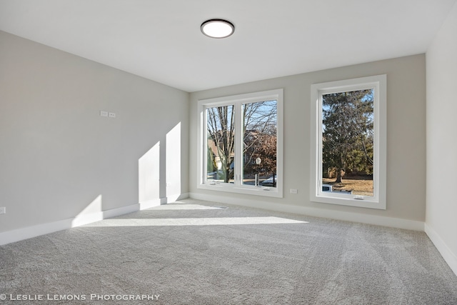 empty room featuring carpet floors and baseboards