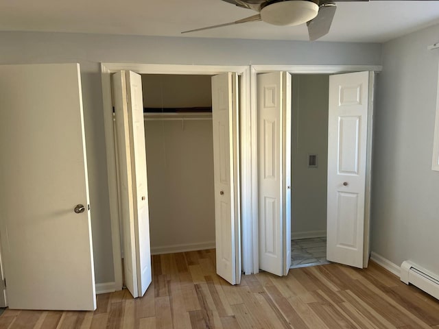 unfurnished bedroom with a baseboard radiator, a ceiling fan, baseboards, and light wood-style floors