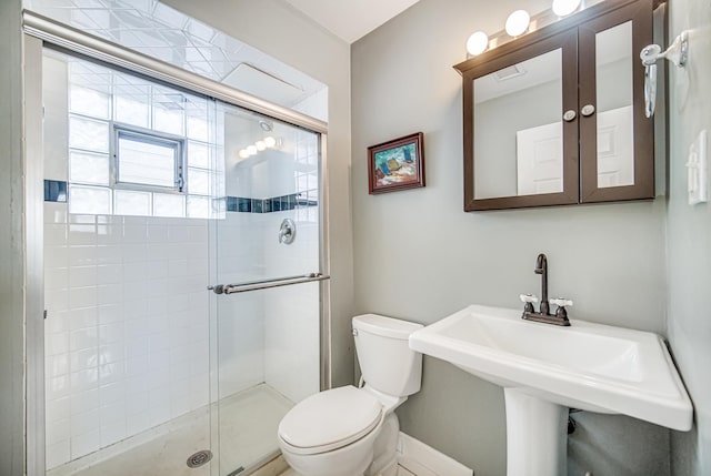 bathroom featuring toilet, a sink, and a shower stall
