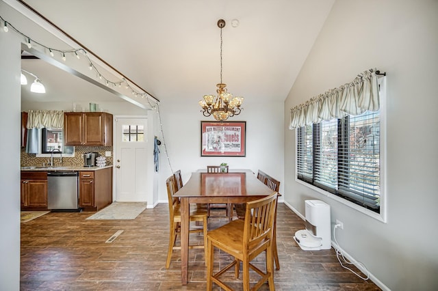 dining area with lofted ceiling, a notable chandelier, baseboards, dark wood finished floors, and track lighting