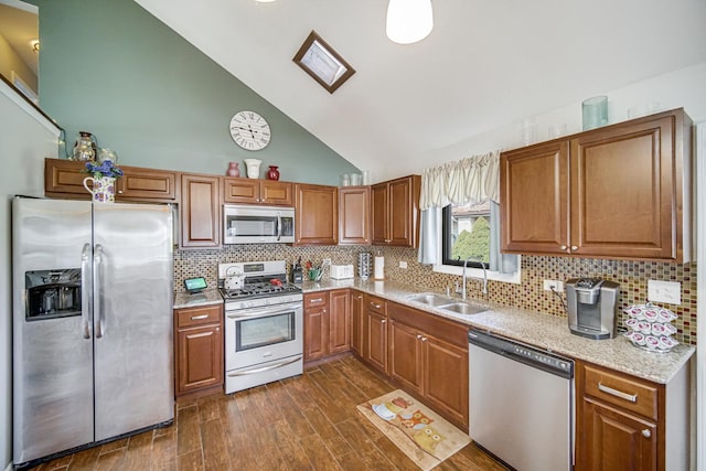 kitchen featuring a sink, brown cabinetry, appliances with stainless steel finishes, and dark wood-style flooring