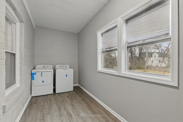 washroom with washing machine and dryer, wood finished floors, laundry area, and baseboards