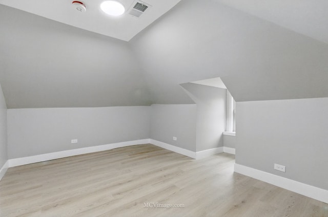additional living space with lofted ceiling, wood finished floors, and baseboards