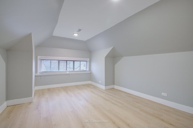 bonus room featuring wood finished floors, vaulted ceiling, and baseboards