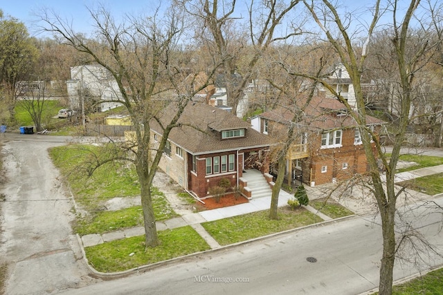 view of front of home with driveway, covered porch, and brick siding