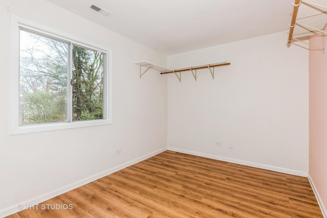 interior space with baseboards, light wood-style floors, and visible vents