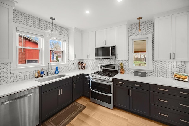 1739 Cedar Rd, Homewood, IL 60430 - kitchen featuring a sink, stainless steel appliances, white cabinetry, tasteful backsplash, and pendant lighting
