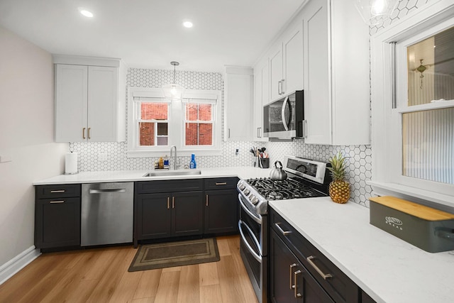 1739 Cedar Rd, Homewood, IL 60430 - kitchen featuring appliances with stainless steel finishes, a sink, light wood-style floors, light countertops, and white cabinetry