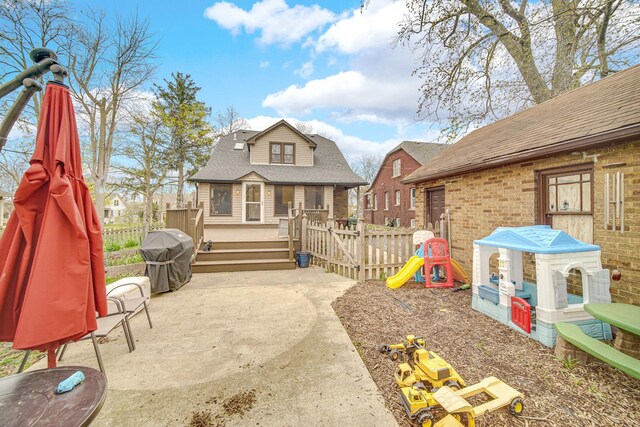 1739 Cedar Rd, Homewood, IL 60430 - back of property featuring fence, a deck, brick siding, a shingled roof, and a patio area