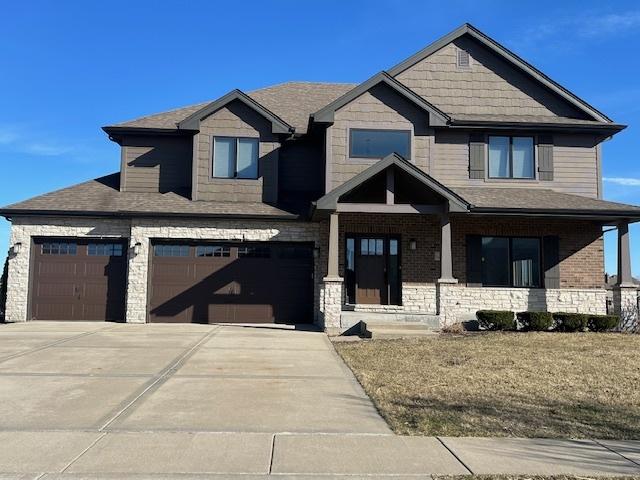 craftsman house with a garage, concrete driveway, and roof with shingles