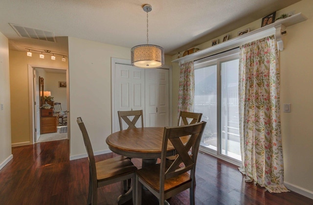 dining area featuring dark wood finished floors, baseboards, and visible vents