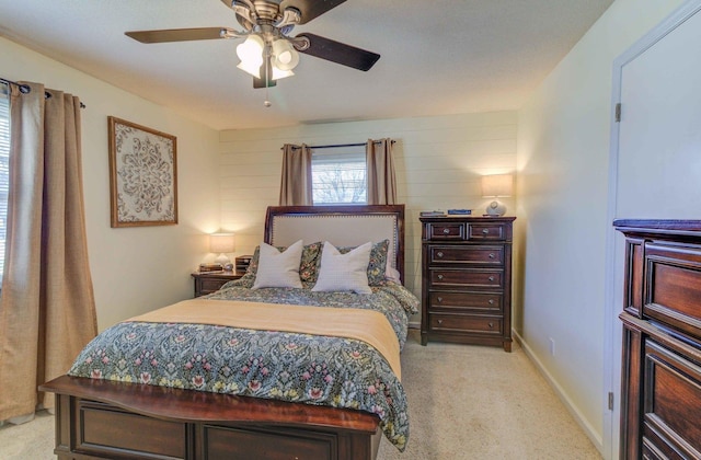 bedroom with a ceiling fan, light carpet, and baseboards