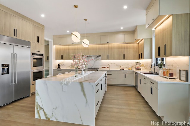 1906 Lee St, Des Plaines, IL 60018 - kitchen featuring a sink, stainless steel appliances, a center island with sink, tasteful backsplash, and light stone counters