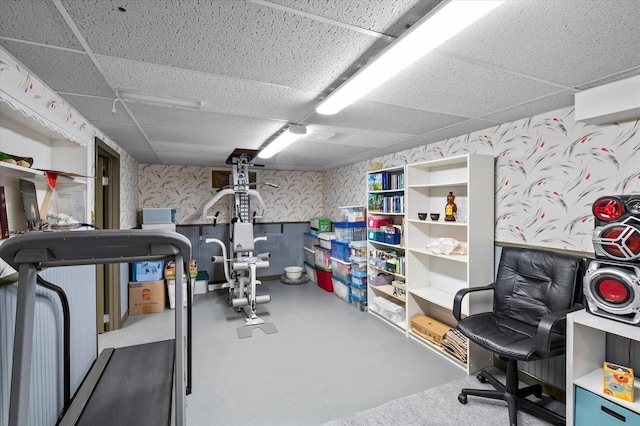workout area featuring wallpapered walls and a drop ceiling