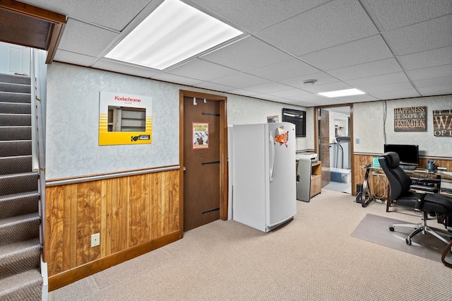 office area with a wainscoted wall, carpet, and a paneled ceiling