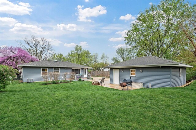 rear view of property featuring a patio, fence, and a yard
