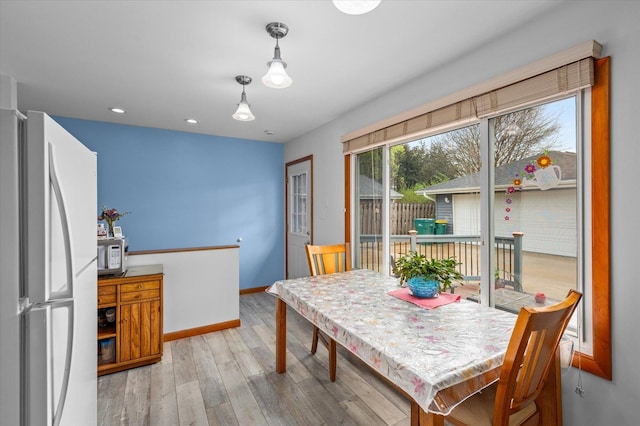 dining space featuring recessed lighting, baseboards, and wood finished floors