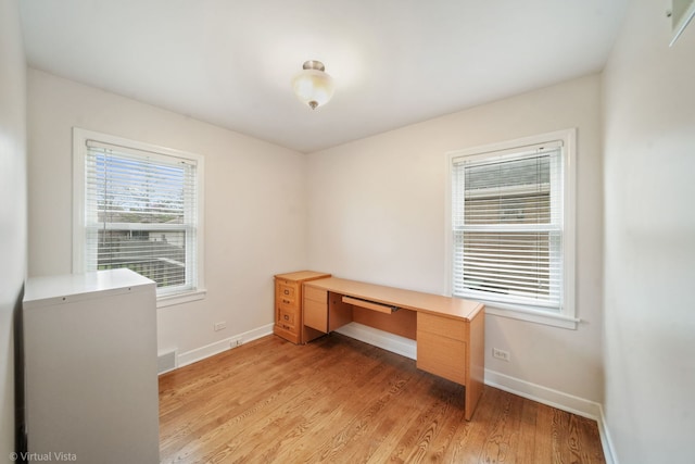 unfurnished office with light wood-style flooring, baseboards, and visible vents