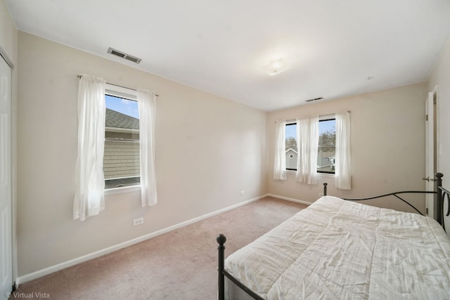 carpeted bedroom with visible vents and baseboards