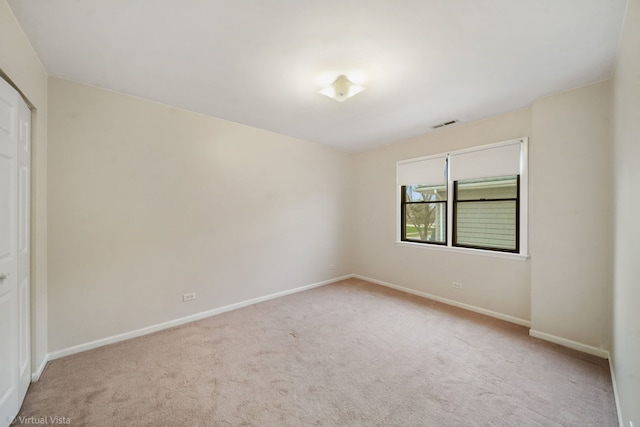 unfurnished room with light carpet, visible vents, and baseboards