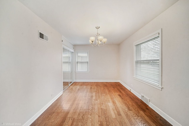 unfurnished dining area with visible vents, plenty of natural light, a chandelier, and light wood-style floors