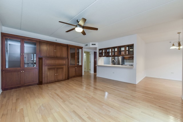 210 N Addison Ave Unit 206, Elmhurst, IL 60126 - unfurnished living room featuring light wood-style floors, baseboards, ceiling fan with notable chandelier, and a sink