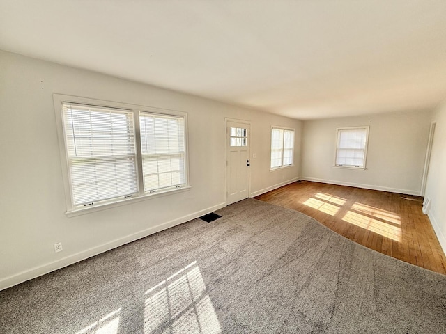 entryway with baseboards, visible vents, and wood finished floors