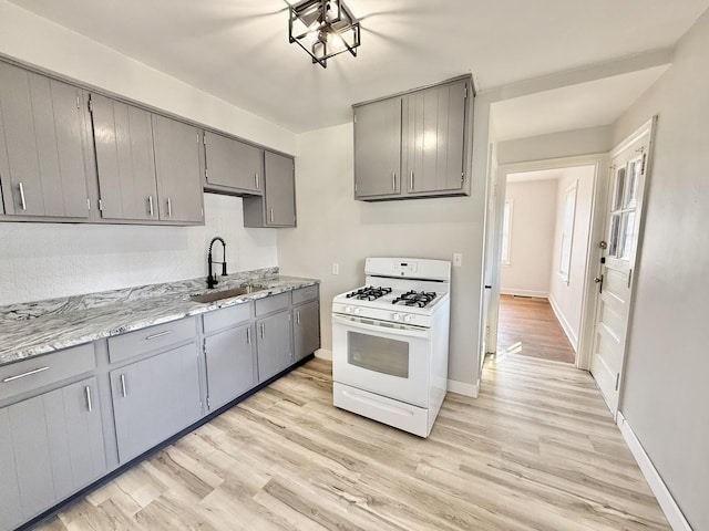 kitchen featuring gray cabinetry and white range with gas cooktop