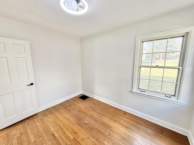 spare room featuring baseboards, visible vents, and light wood finished floors