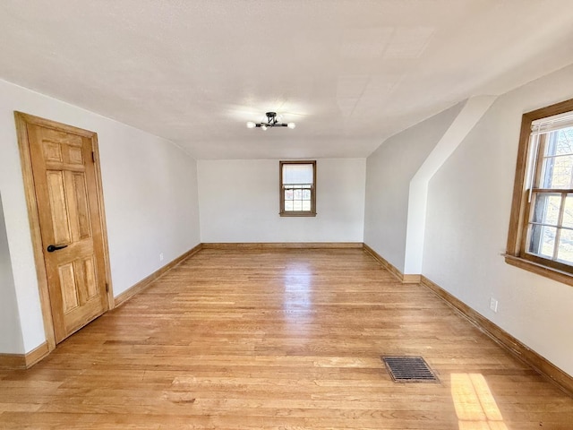 bonus room featuring light wood-style flooring, baseboards, and visible vents