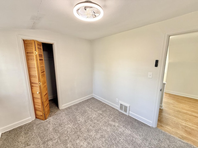 unfurnished bedroom with baseboards, visible vents, a closet, and carpet flooring