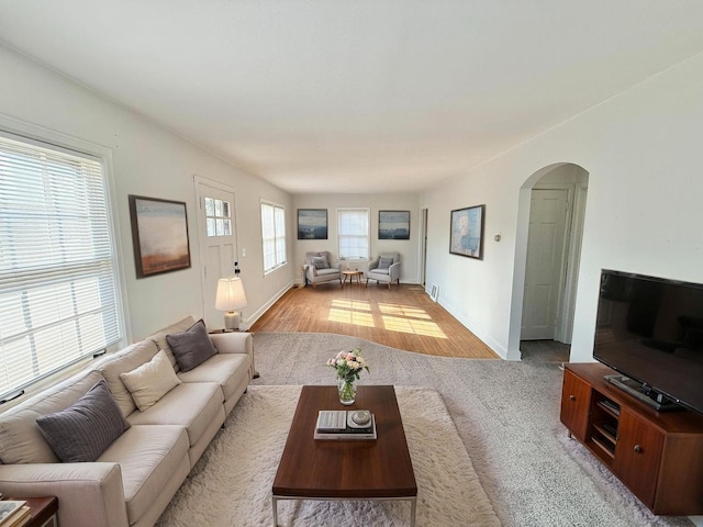 living area featuring arched walkways and baseboards
