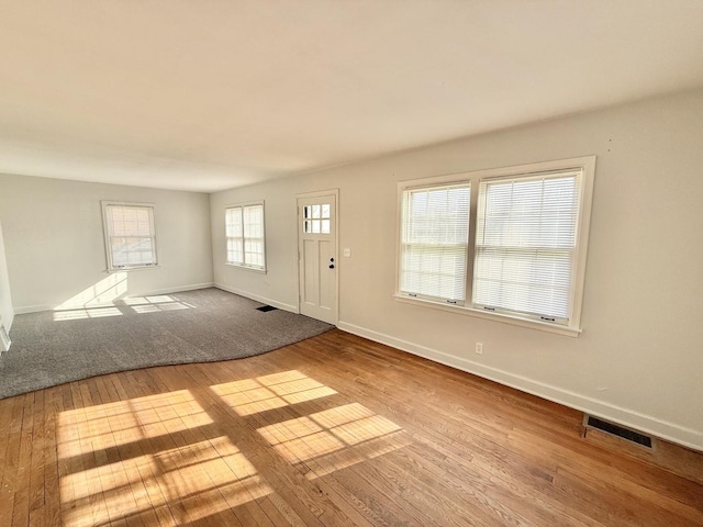 entrance foyer with baseboards, visible vents, and hardwood / wood-style flooring