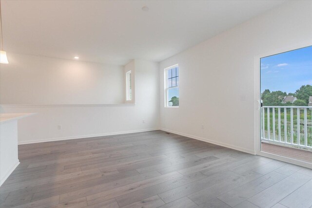 unfurnished room with baseboards, wood finished floors, and recessed lighting