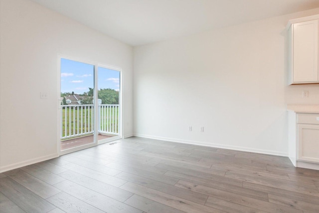 unfurnished living room with baseboards and light wood-style flooring
