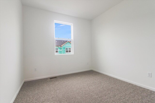 unfurnished room featuring baseboards, visible vents, and carpet