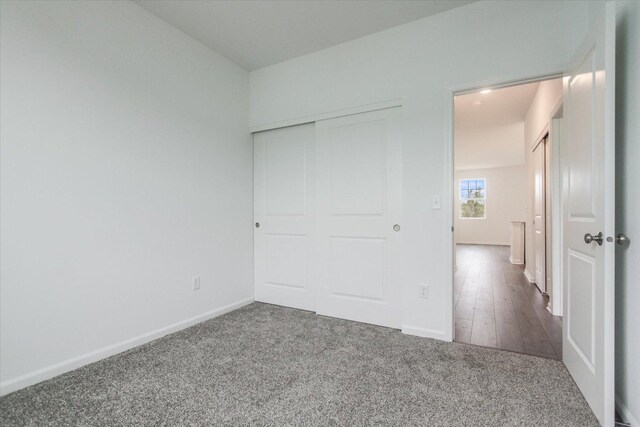unfurnished bedroom featuring a closet, baseboards, and carpet