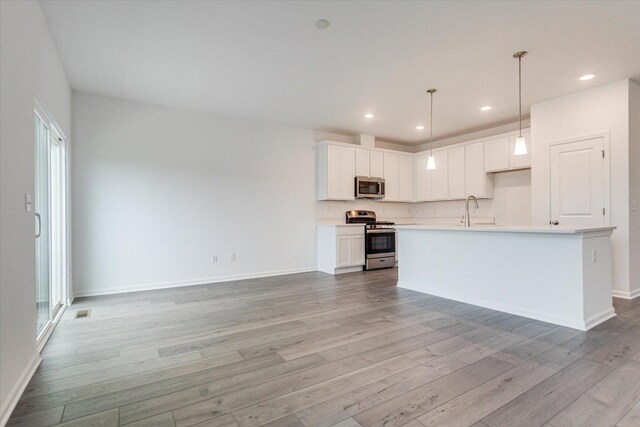 kitchen featuring light wood-type flooring, light countertops, white cabinetry, and stainless steel appliances