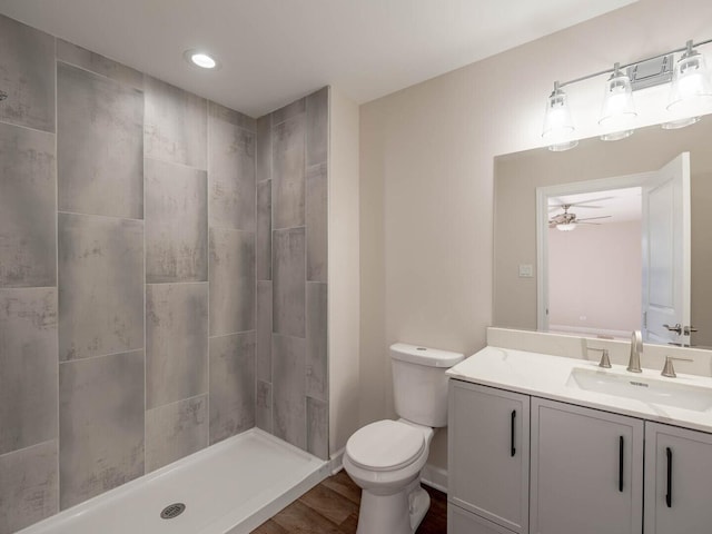 347 Madison Ave, Calumet City, IL 60409 - bathroom with a tile shower, toilet, vanity, a ceiling fan, and wood finished floors