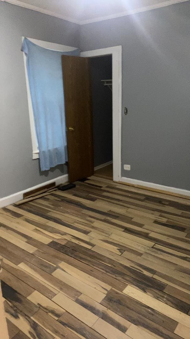 unfurnished room with baseboards and wood finished floors